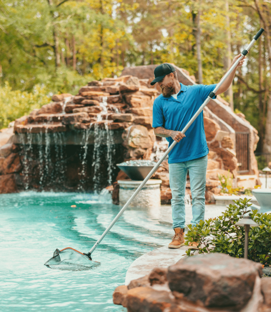 Man sweeping with net cleaning pool.