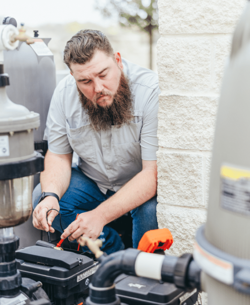 Hauk Pools employee fixing pool system.