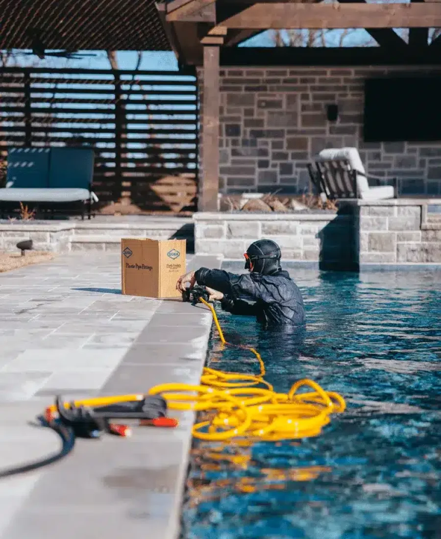 Hauk Pools employee fixing pool system.