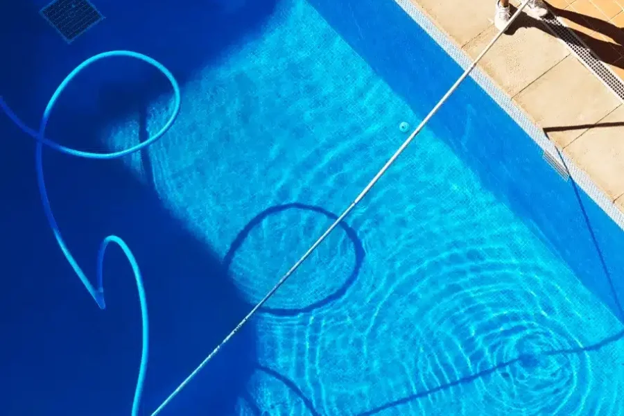 pool-cleaning1 Man cleaning pool.